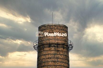 Old Industrial Brick Chimney Against Dramatic Sky
